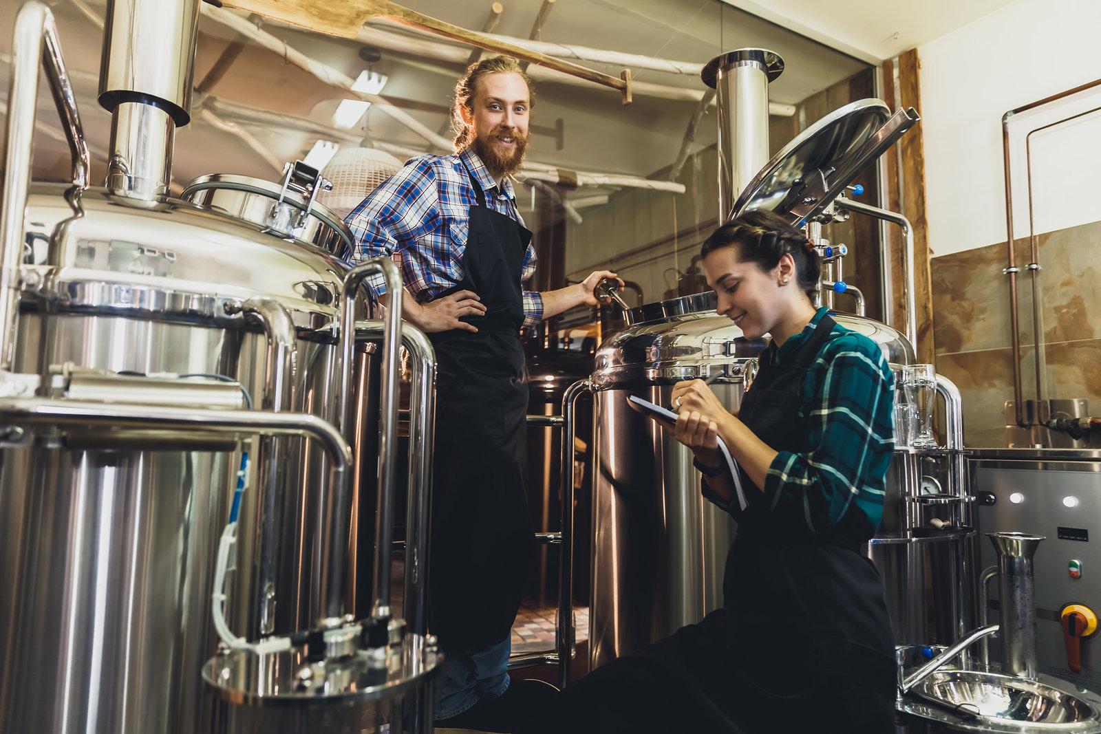 Man and woman brewing beer with giant mashtons